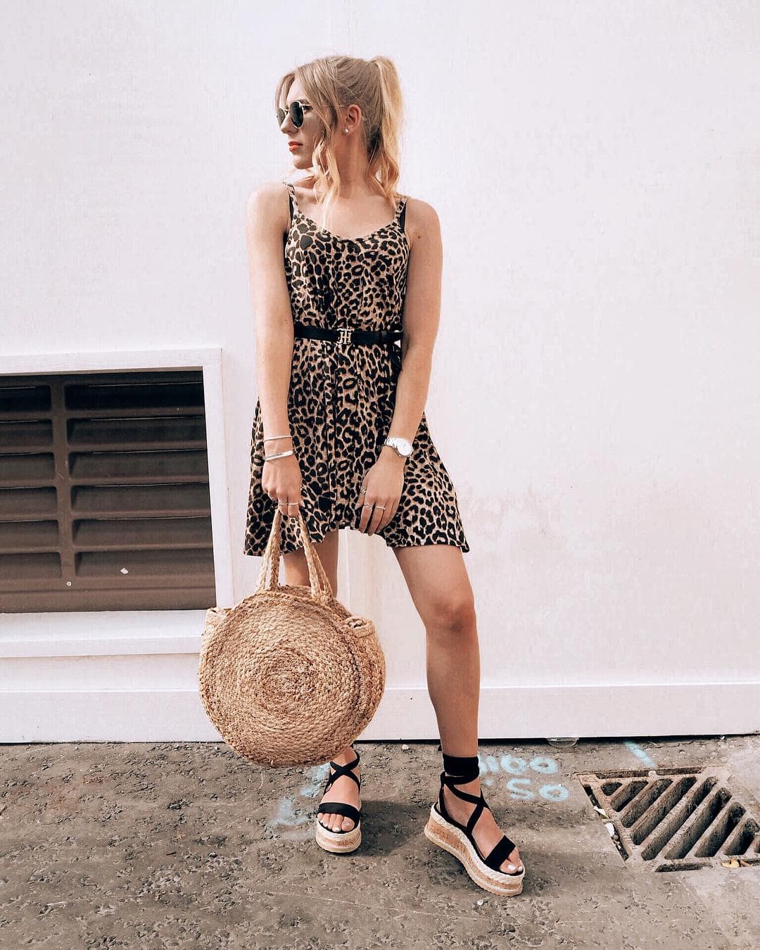 An image of a woman in a animal print dress wearing a pair of black flatform espadrilles